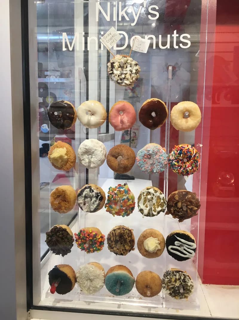 Niky's Mini Donuts acrylic display wall of topped mini donuts in the shop window